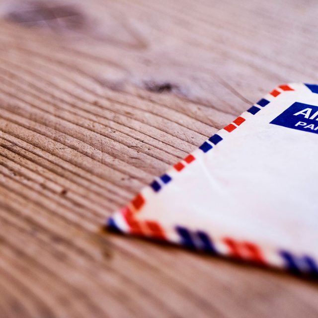 Ein Luftpost-Briefumschlag liegt auf einem Holztisch