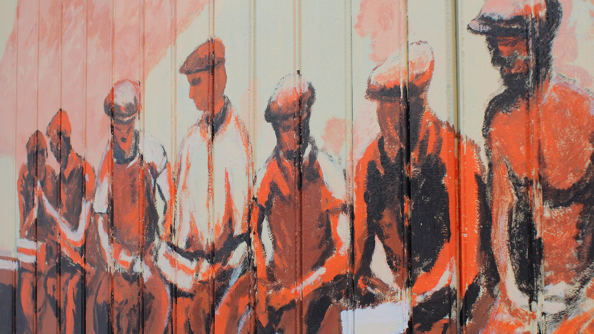 Ein Wandgemälde in Braun- und Orangetönen: Bauarbeiter sitzen auf einer Mauer
